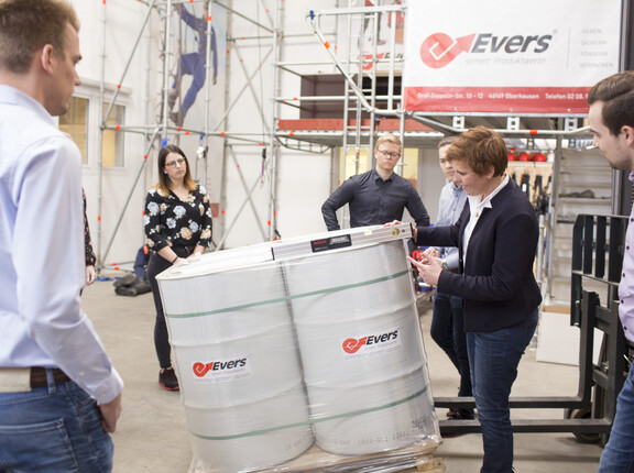 Evers-Mitarbeiter führen einen Kipptest an einer Palette, beladen mit Fässern, durch