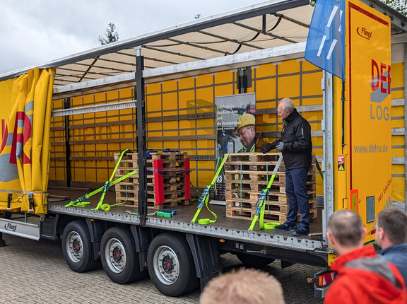 Mit Zurrgurten gesicherte Ladung auf der Ladefläche eines offenen LKW-Anhängers