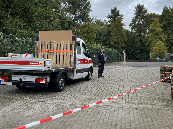 Ein Transporter mit offener Ladefläche und gesicherte Ladung, davor ein Evers-Mitarbeiter.